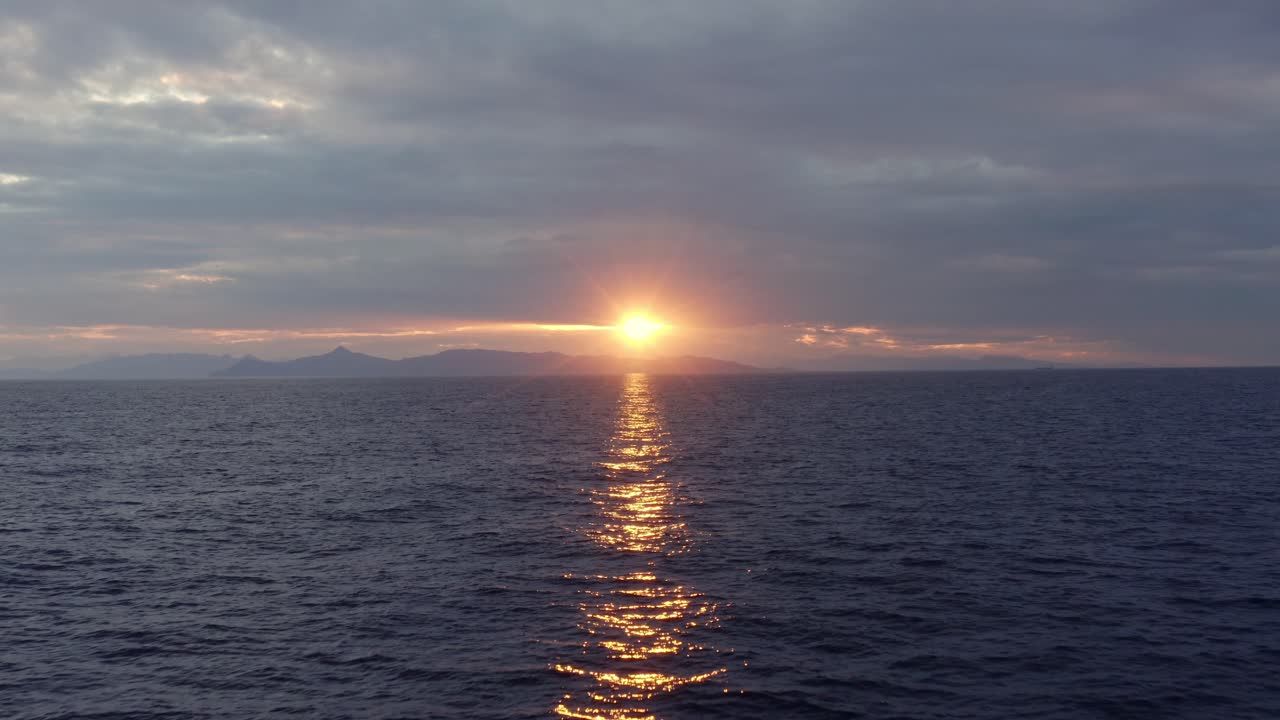 공중 - 석양에 바다 위로 뒤로 비행