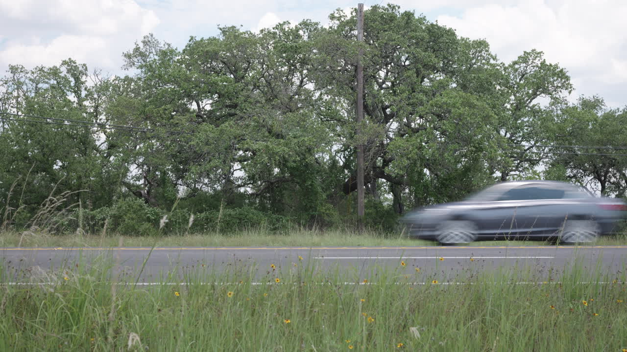 SUVs and Trucks drive along Highway 281 in the Texas Hill Country, near Johnson City, Texas - Slider left to right