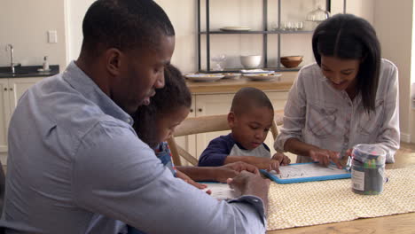 parents and children drawing on whiteboards at table