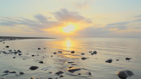 Shoreline-with-distant-seabird-in-slow-motion-during-sunset-at-Fleetwood,-Lancashire,-UK