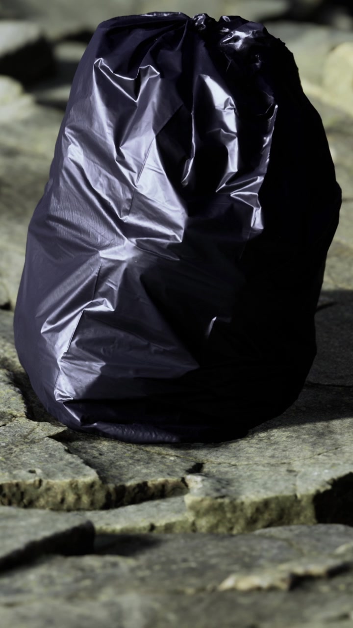 Sacchetto della spazzatura posizionato su una superficie di pietra all'aperto durante le ore diurne