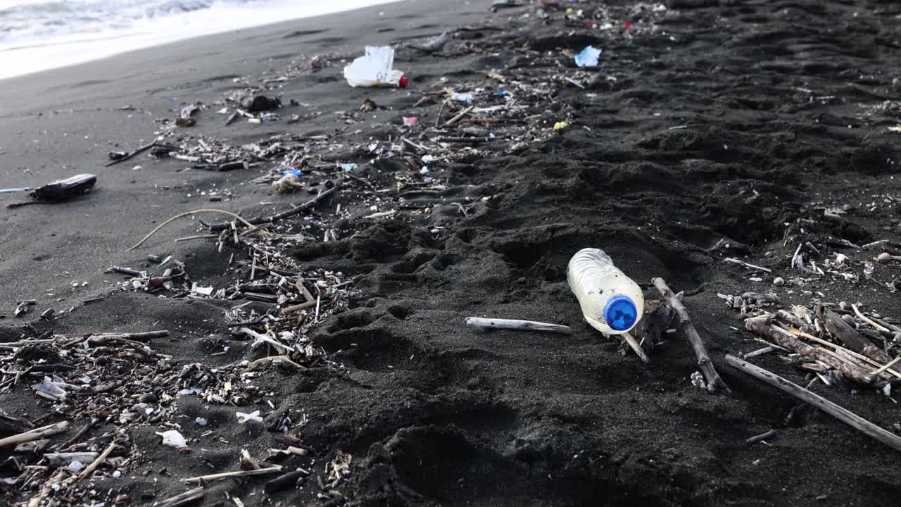 Polluted Black Sand Beach with Plastic and Debris
