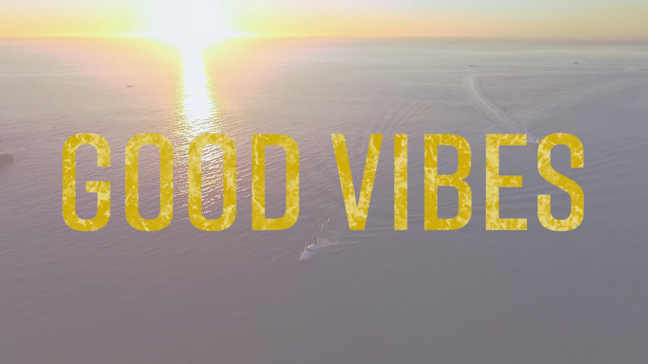 Animering av orden 'good vibes' skrivna med gula bokstäver med solnedgång över lugnt hav