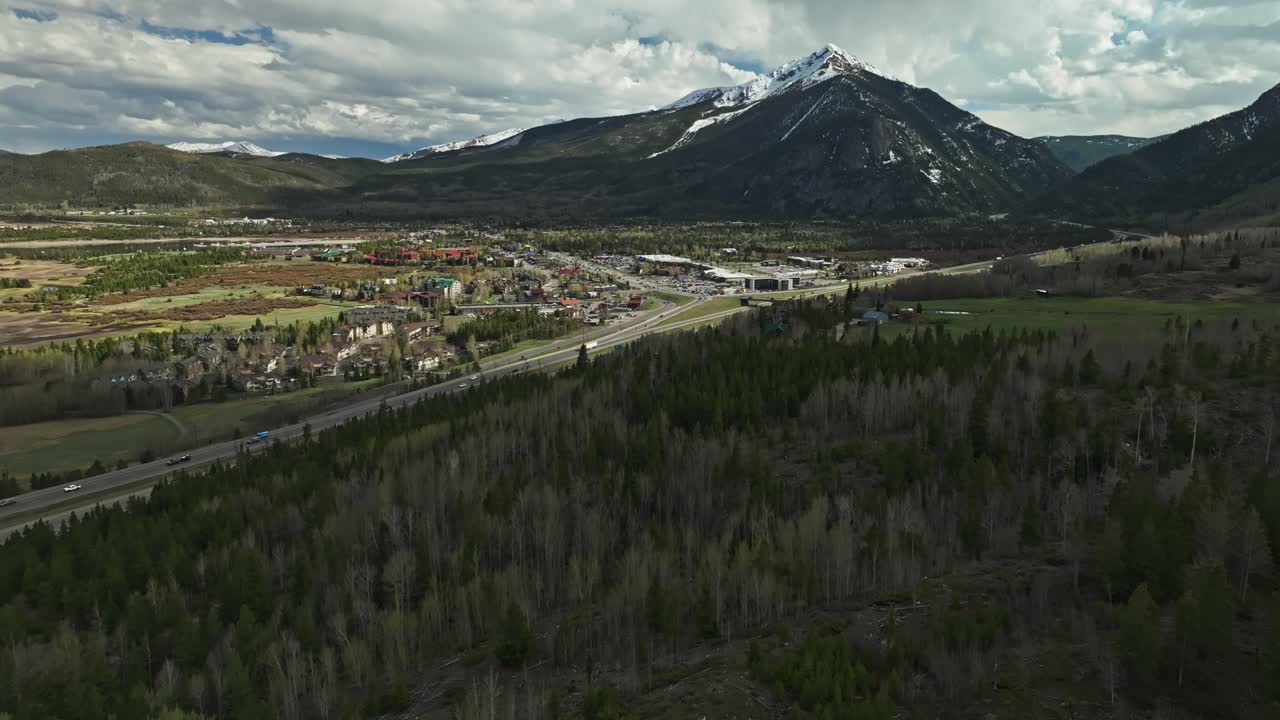 árboles desnudos mezclados con árboles de hoja perenne por encima de la carretera que conduce a frisco colorado