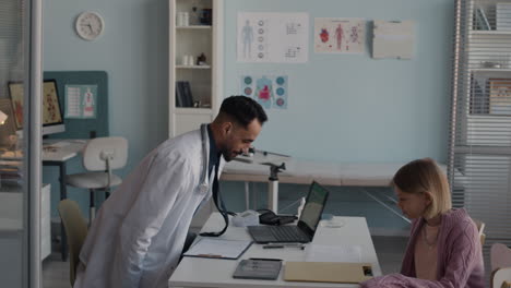doctor consulting with patient and mother in clinic