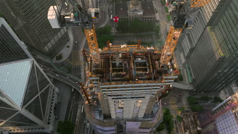 large skyscraper being built in modern dense city, drone close up establishing shot