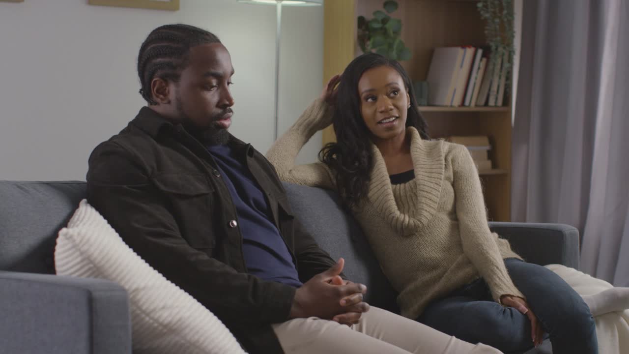 Couple At Home Sitting On Sofa In Lounge Having Break Up Argument