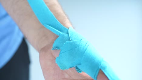 man showing kinesiology taping on his thumb