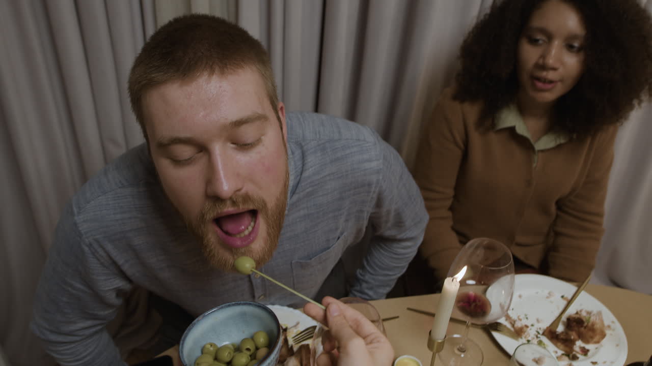People Enjoying a Candlelit Dinner with Olives
