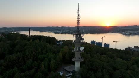 sunset reflects off calm waters with radio tower in silhouette