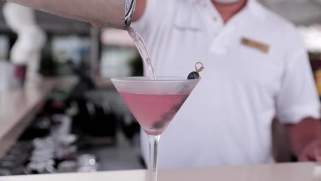 el barman hace un martini colorido.