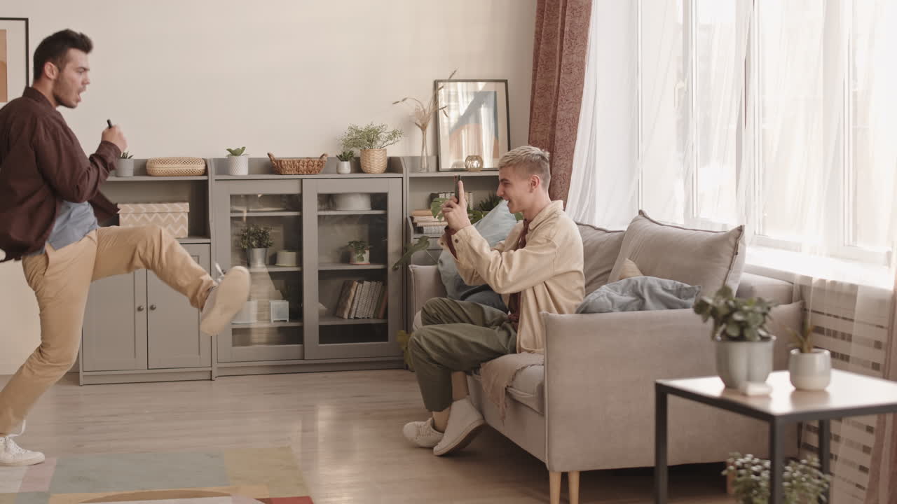 Young Man Shooting on Smartphone His Boyfriend Dancing