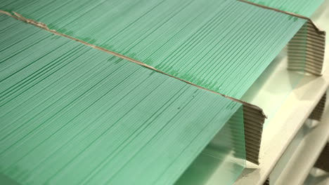 three rows of small square-shaped glass products stacked on top of each other in the warehouse