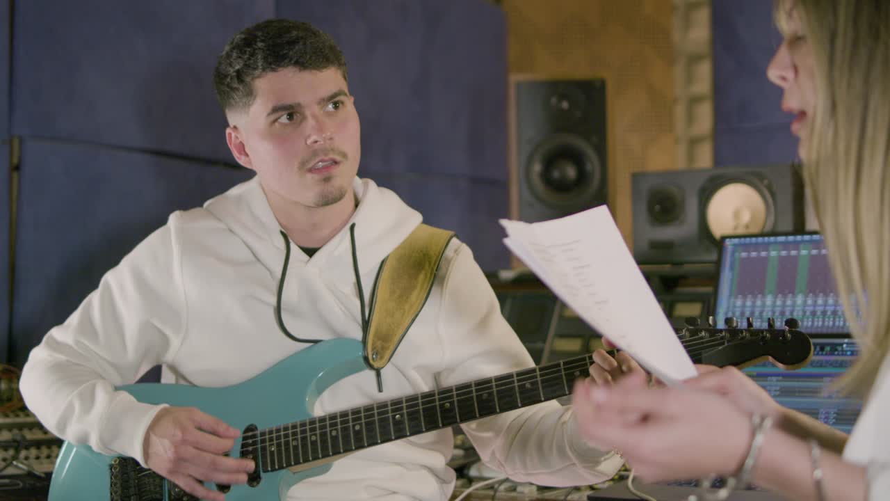 새로운 노래를 녹음하는 동안 음악 스튜디오에서 일하는 두 명의 음악가