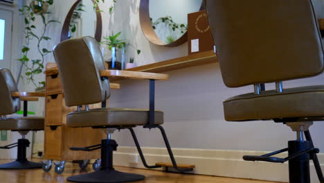 Slide-along-the-floor-of-a-hair-salon-with-hairdresser-seats-in-shot,-very-cinematic