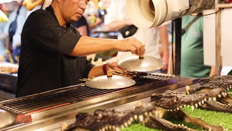 vendor grilling crocodile meat at street food market