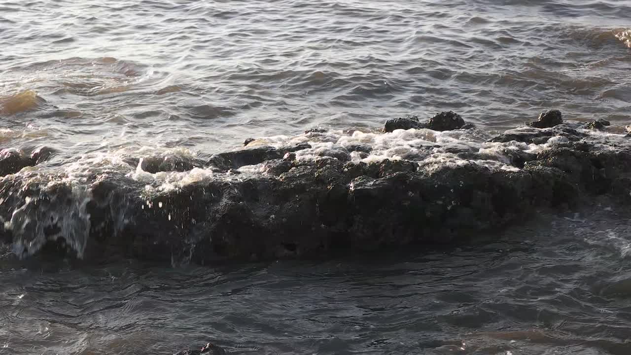 rallentatore della barriera della spiaggia colpita dalle onde del mare