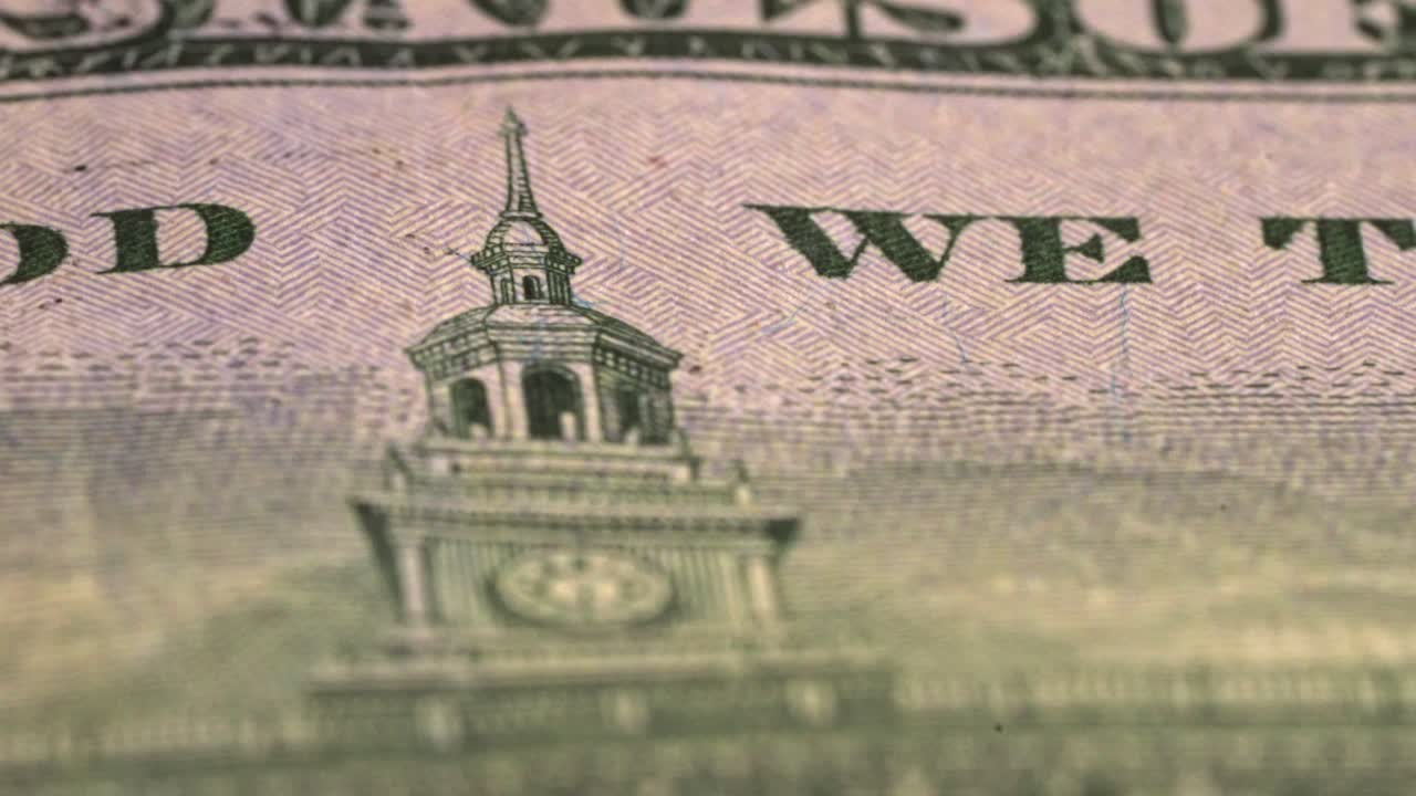 Close view of US currency with motto and building details