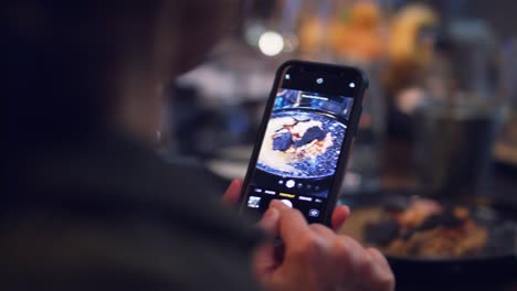 tomando una foto con un smartphone de la comida en el restaurante
