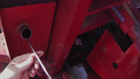 checking hydraulic oil level in a large articulated farm tractor