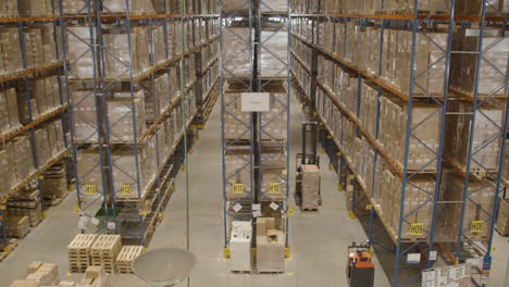 high angle view of forklift with boxes driving through industrial warehouse