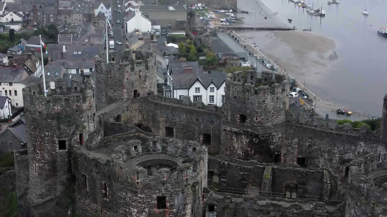 Vista aerea dello storico Castello di Conwy, punto di riferimento cittadino in rovina con mura in pietra e merlature, attrazione turistica, ripresa aerea con allontanamento.