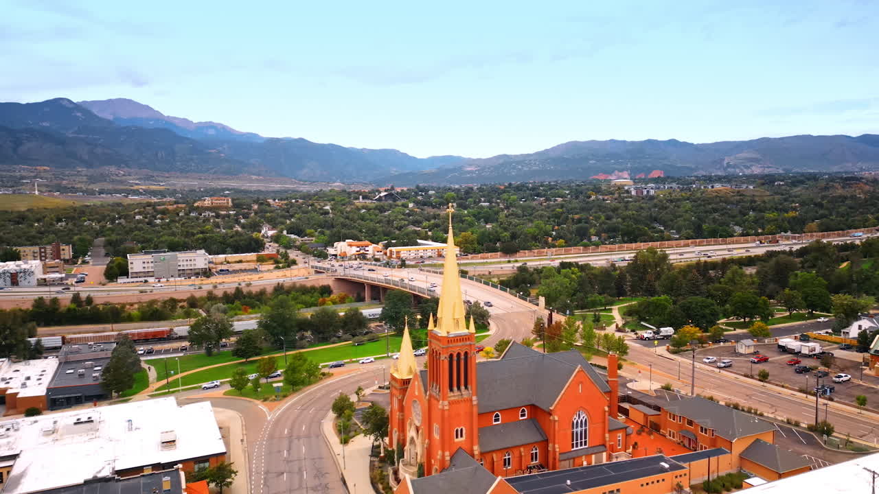 Beautiful green scenery of Colorado Springs, Colorado, USA. Drone flight at the church steeple revealing view on the heavy traffic in the city
