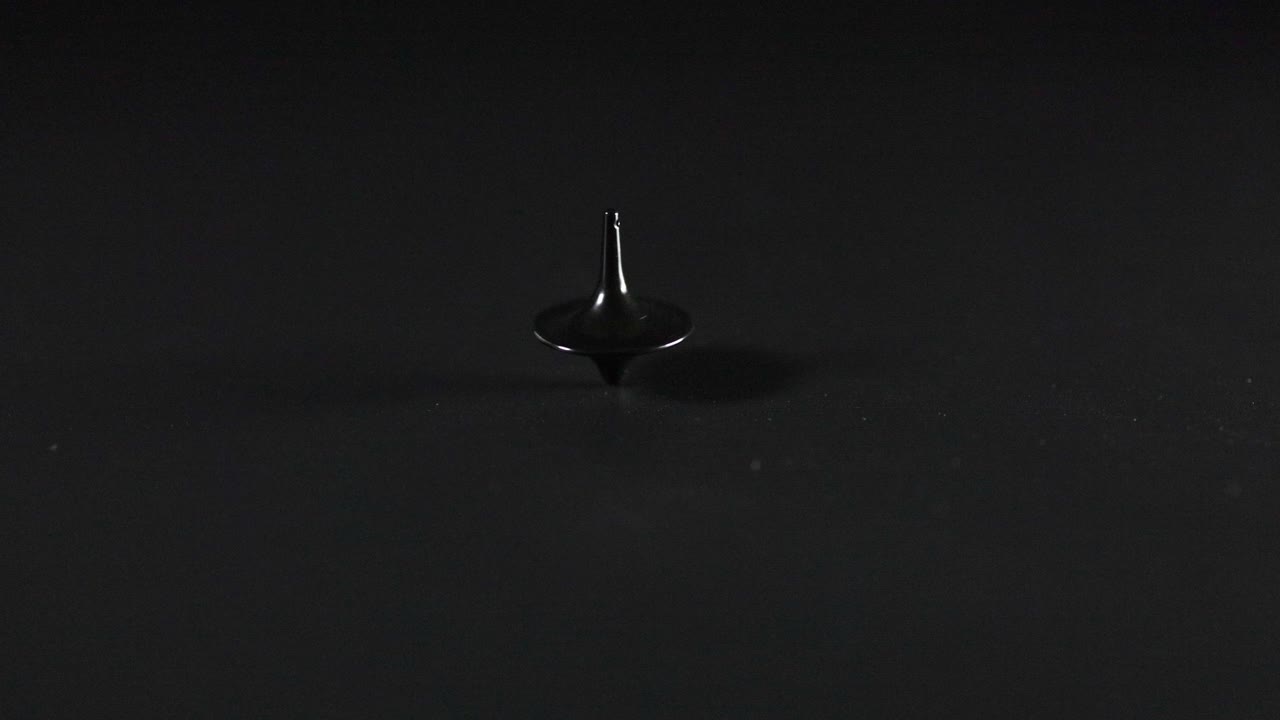 暗い表面で回転するスピニングトップ