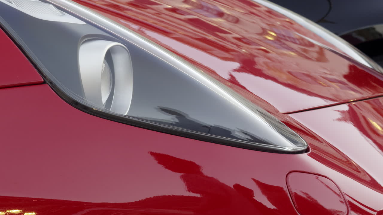 Close-up of a red car's hood and headlights