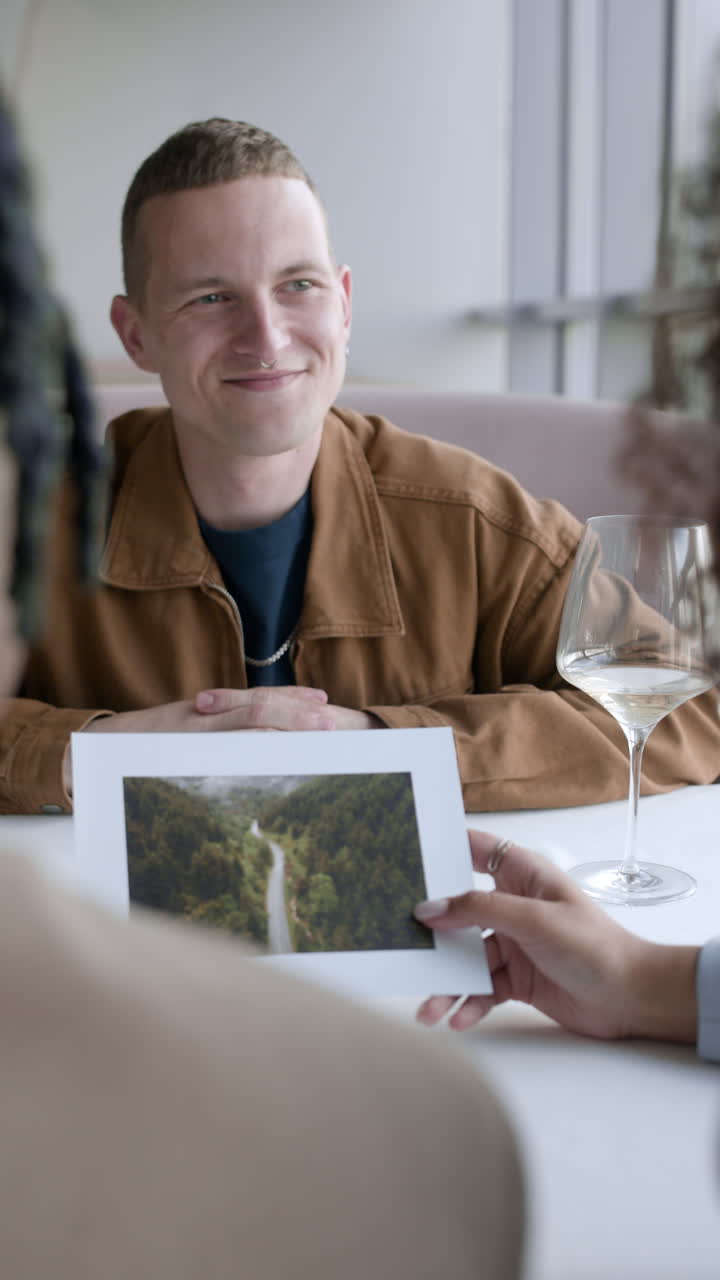 Venner spiser aftensmad og kigger på et foto
