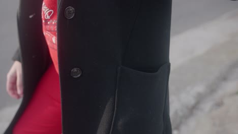 close up of a woman's hand taking out a surgical mask out of her coat pocket