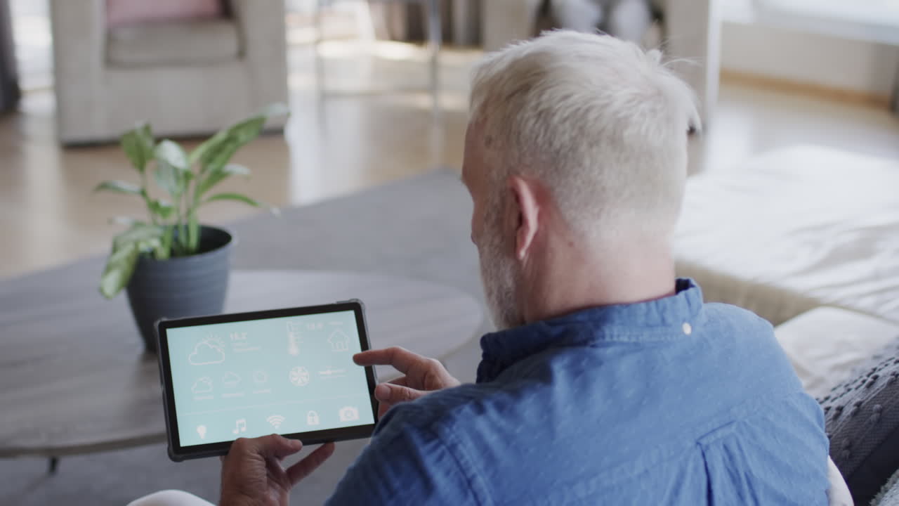 중년 백인 남자가 집에서 태블릿을 사용하고, 복사 공간, 느린 동작