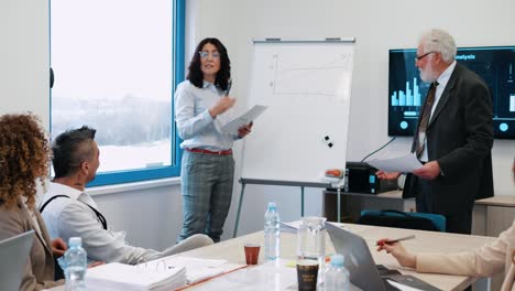 mujer de negocios dando una presentación a sus colegas en la sala de reuniones de negocios