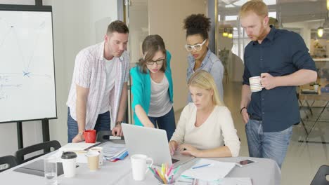 coworkers with laptop in office