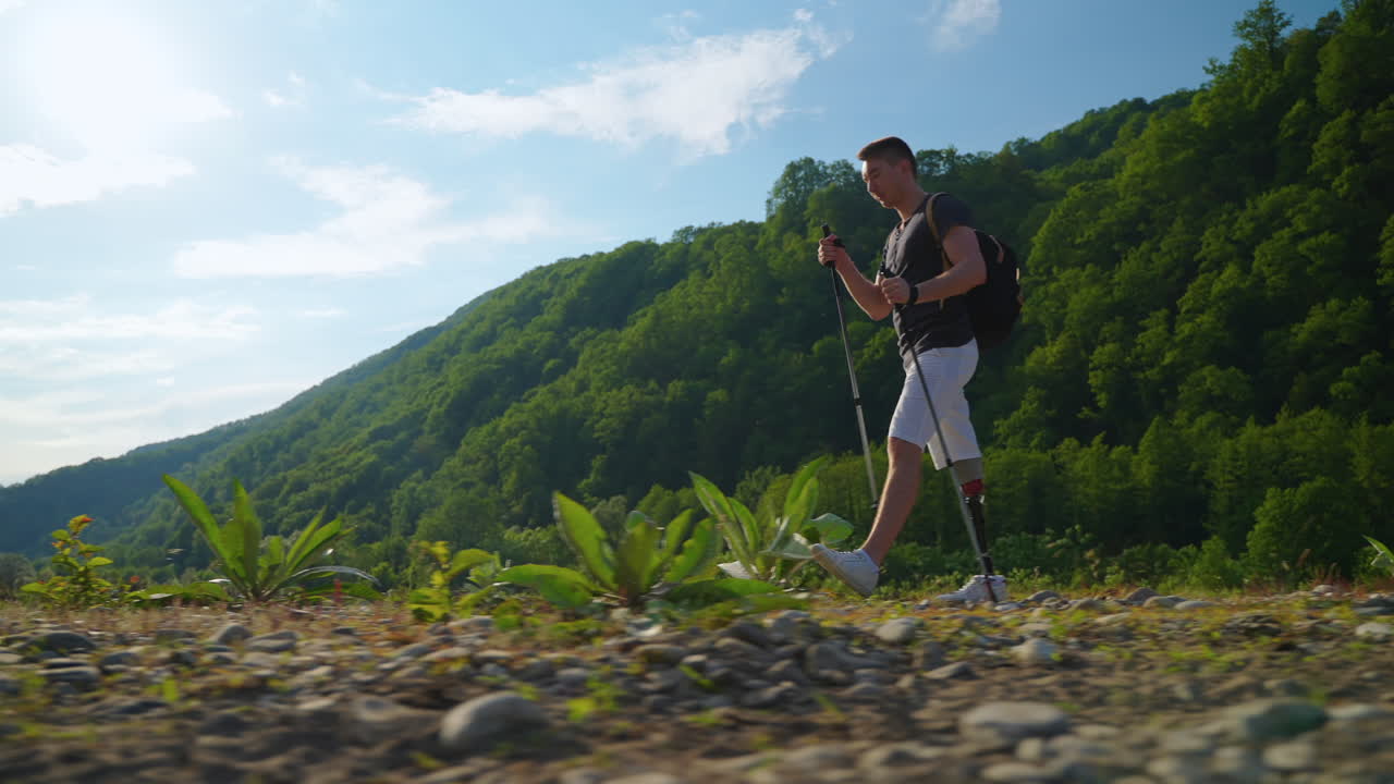 hombre con pierna protésica caminando por las montañas