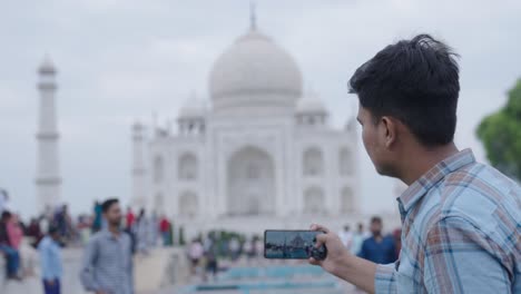 friends clicking pictures in front of taj mahal