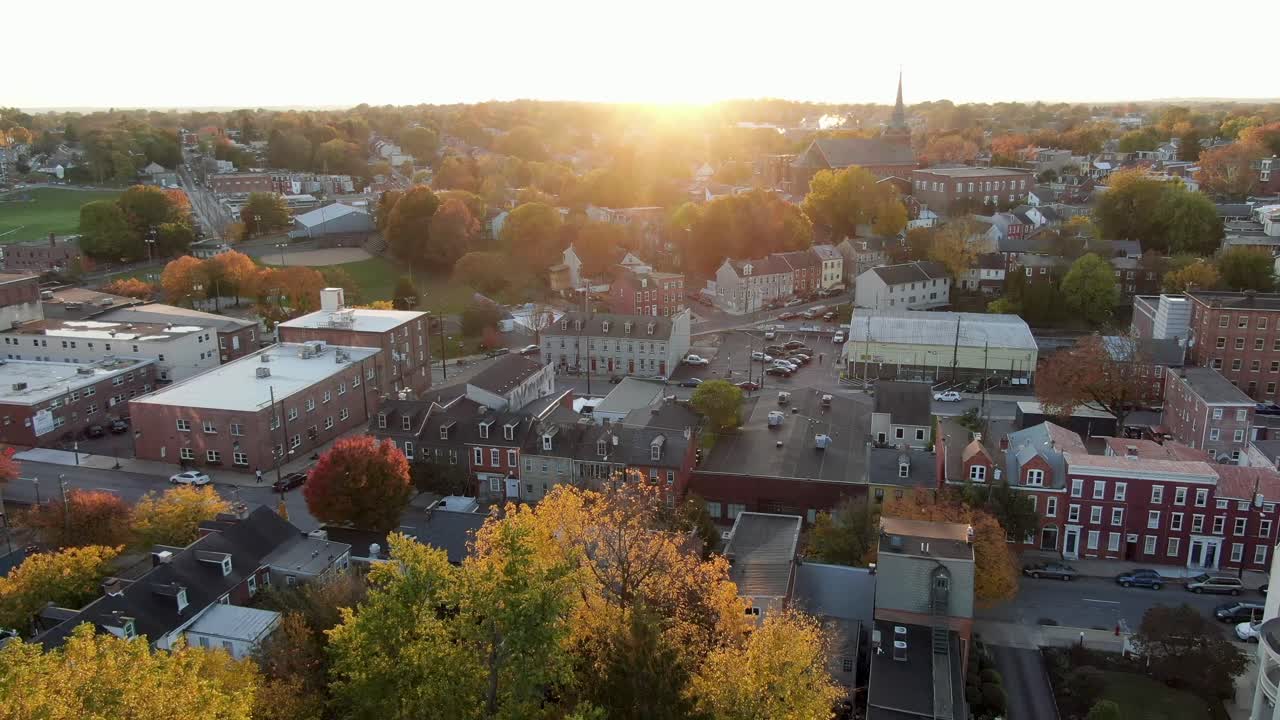 Aerial turn of cityscape during dramatic sunset sunrise, school church homes visible in urban setting in Lancaster Pennsylvania USA