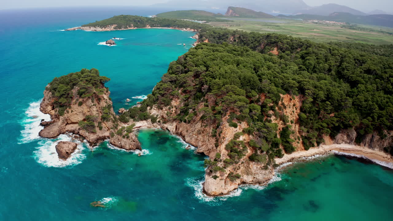 Vista aerea di lussureggianti scogliere costiere e mare turchese.