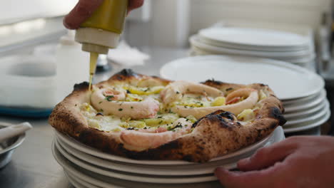 Chef Putting Last Bit Of Oil On Top Of The Hot Octopus Pizza
