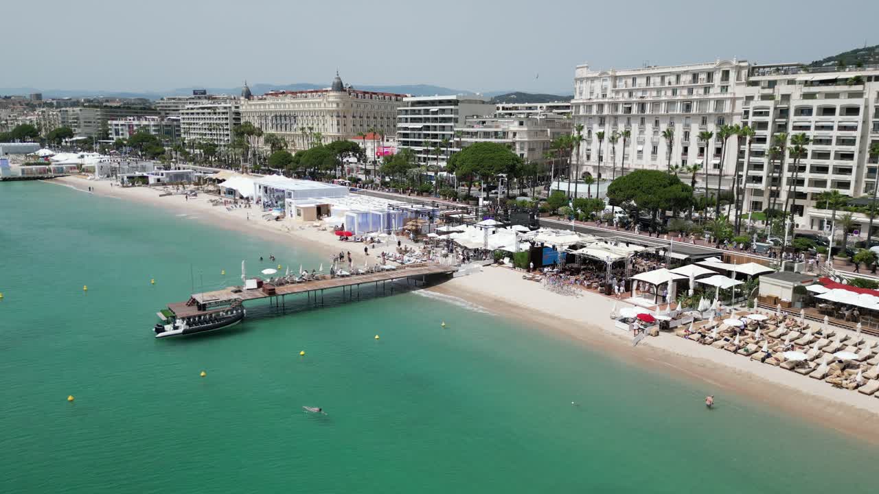 Ripresa panoramica bassa di un evento sulla spiaggia di Cannes, Francia. Drone, aerea.