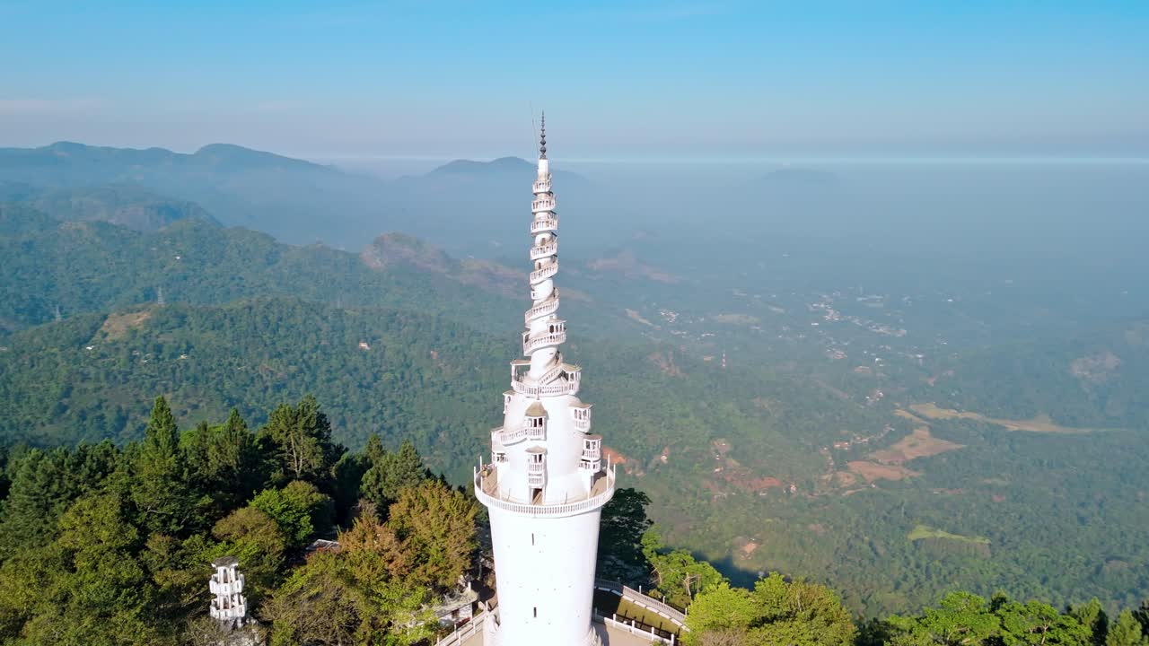 Experience the grandeur of Ambuluwawa Tower close to Kandy city at sunrise, captured from a drone (orbit shot).