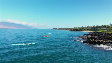 tourist in kayaks and outrigger canoes off the coast of wailea maui, hawaii