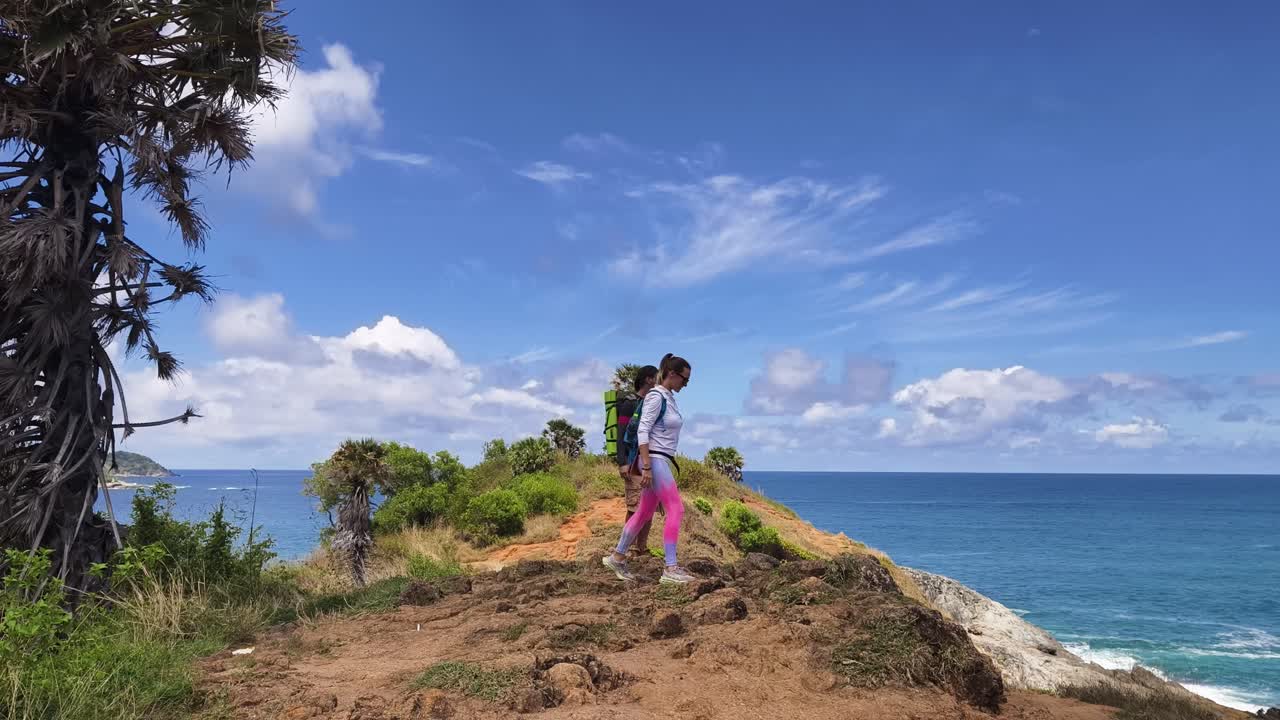 Couple Hiking on a Cliff Overlooking the Ocean