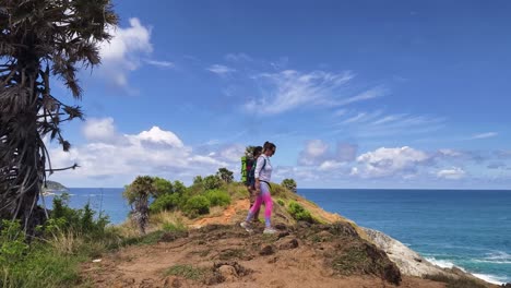 couple hiking on a cliff overlooking the ocean