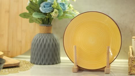 yellow decorative plate on wooden stand with flowers