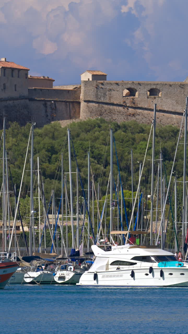 Boats moving through the Port Vauban with the Fort Carre on the background. Vertical, Antibes, France