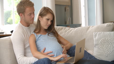 couple with pregnant woman using laptop computer shot on r3d