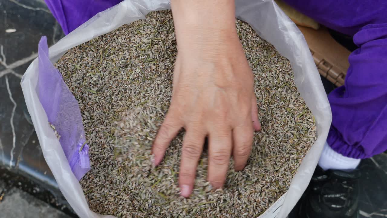 mujer sosteniendo una bolsa de flores de lavanda secas