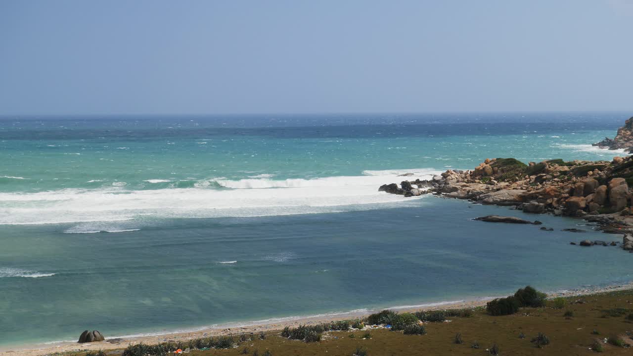 Spiaggia tranquilla con onde calme e sinuose.