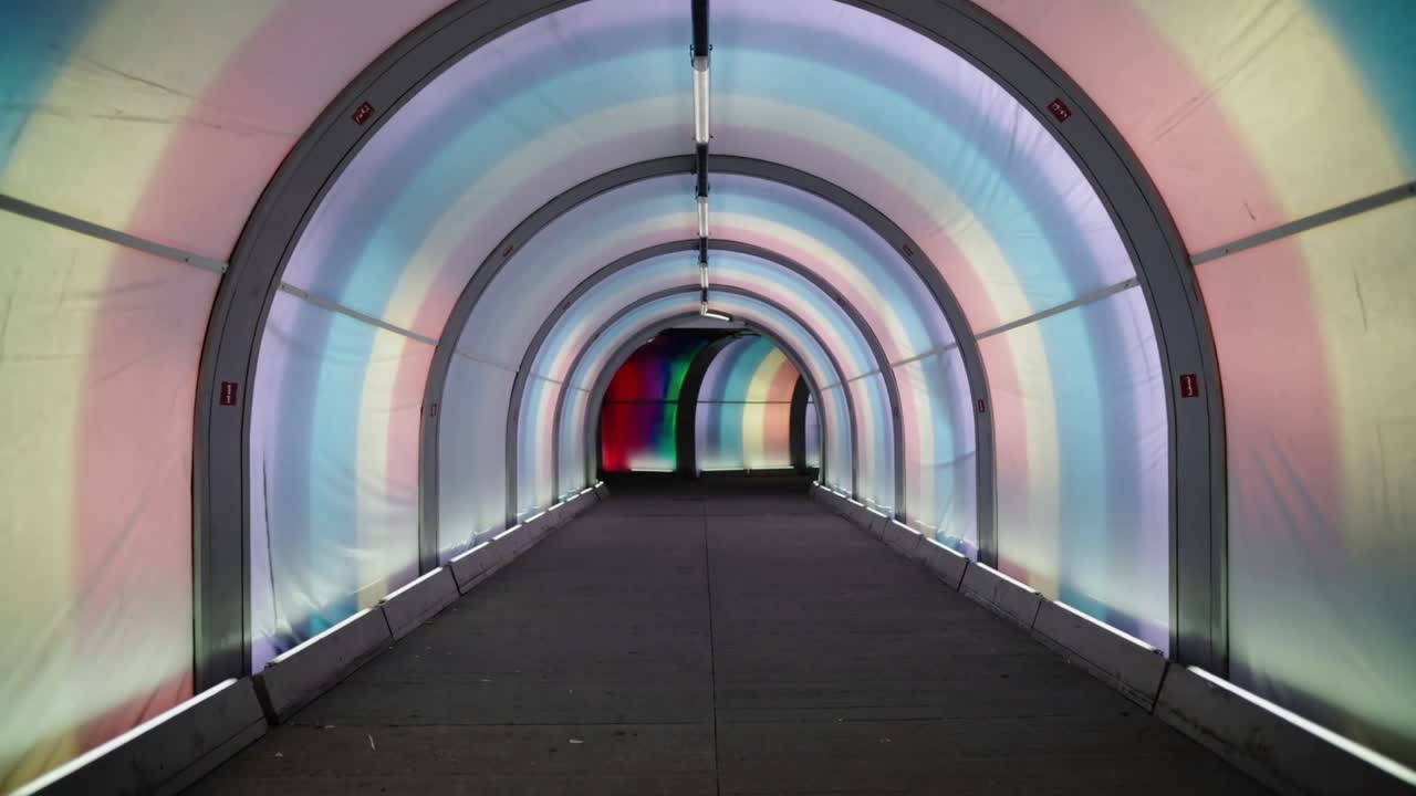 LED lighting initiating color shift across arched ribs toward green exit, guiding transit